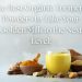 Glass of golden milk with bowls of turmeric powder, fresh turmeric roots, cinnamon sticks, and spices on a soft background.