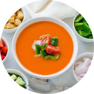 Spanish gazpacho served with fresh toppings — a classic among cold summer soups.