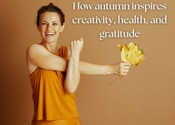 Smiling woman in warm autumn tones holding golden leaves, symbolizing autumn activities and seasonal wellbeing.